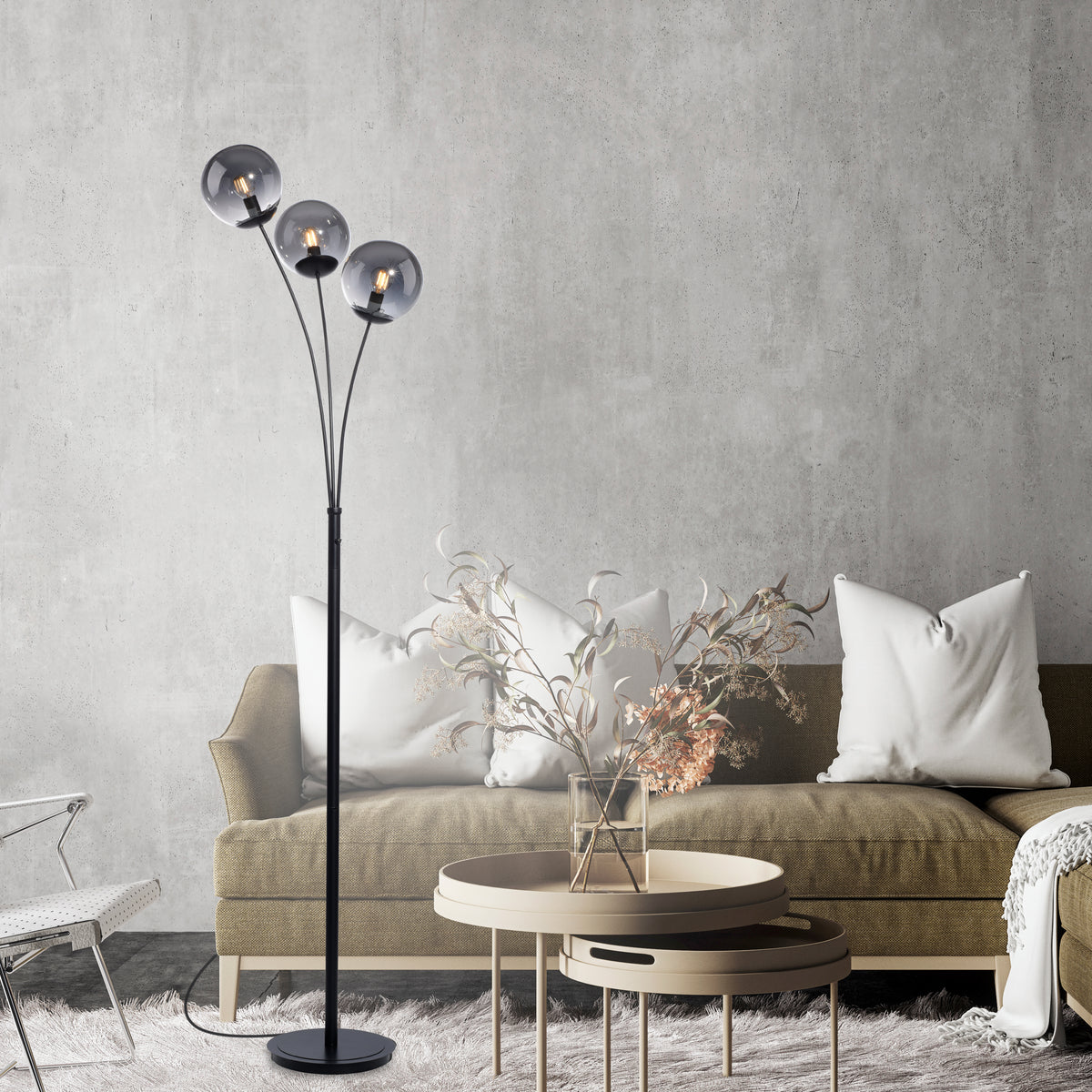Mise en ambiance salon : lampadaire allumé derrière un canapé beige.