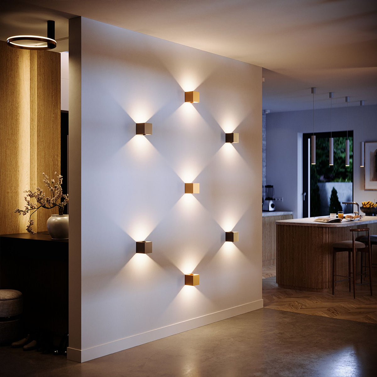 Plusieurs appliques cubiques dorées et noires installées sur un mur blanc en mise en ambiance.