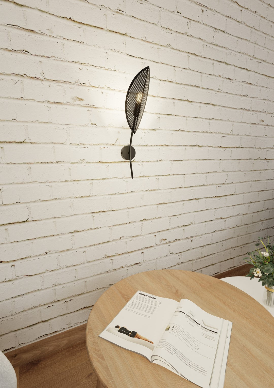 Vue en situation de l’applique feuille sur brique blanche, magazine sur table
