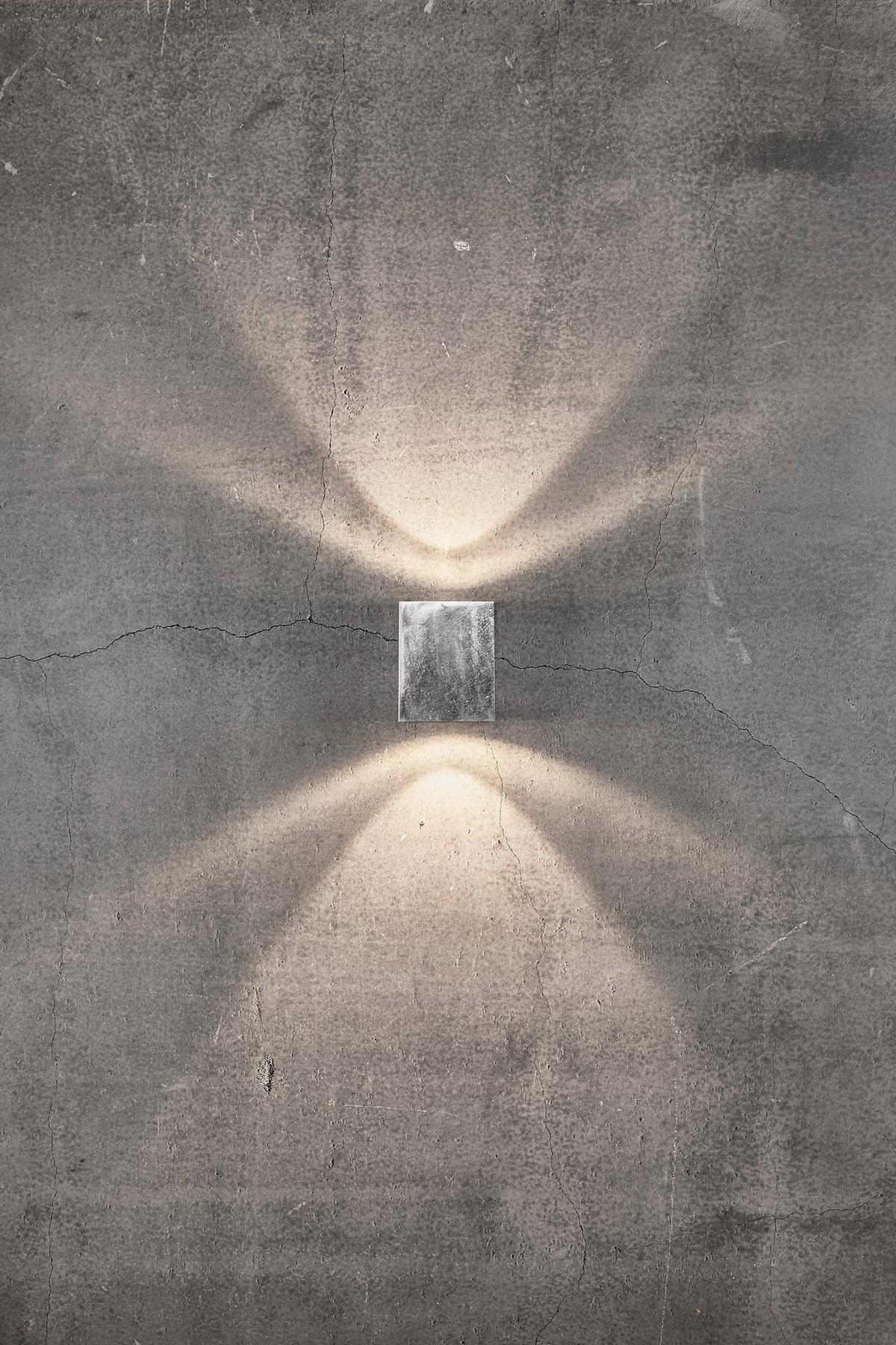 Mise en ambiance sur mur béton fissuré, faisceaux lumineux orientés haut et bas.