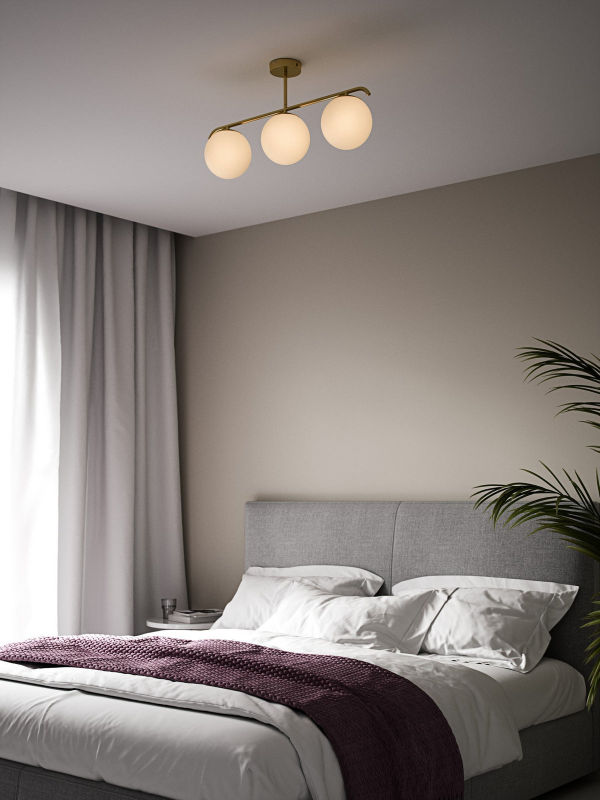 Mise en ambiance chambre avec plafonnier trois globes allumés au-dessus du lit
