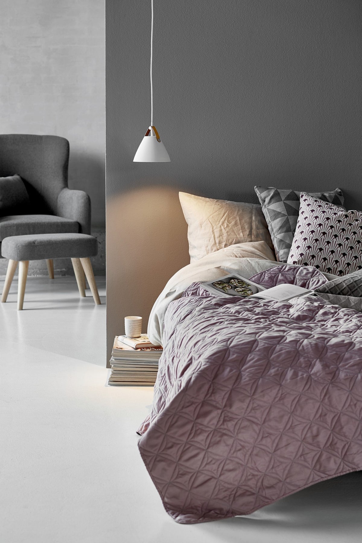 Mise en ambiance chambre, suspension blanche allumée au-dessus de la tête de lit