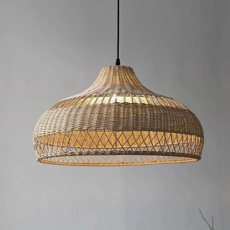Vue de trois quarts du luminaire suspendu, abat-jour rotin tressé, lumière chaude.