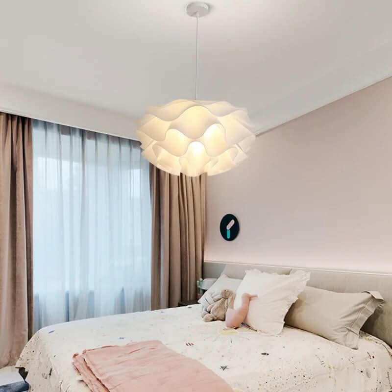 Vue en situation dans une chambre d'enfant, suspension fleur éclairée, rideaux beiges et lit blanc