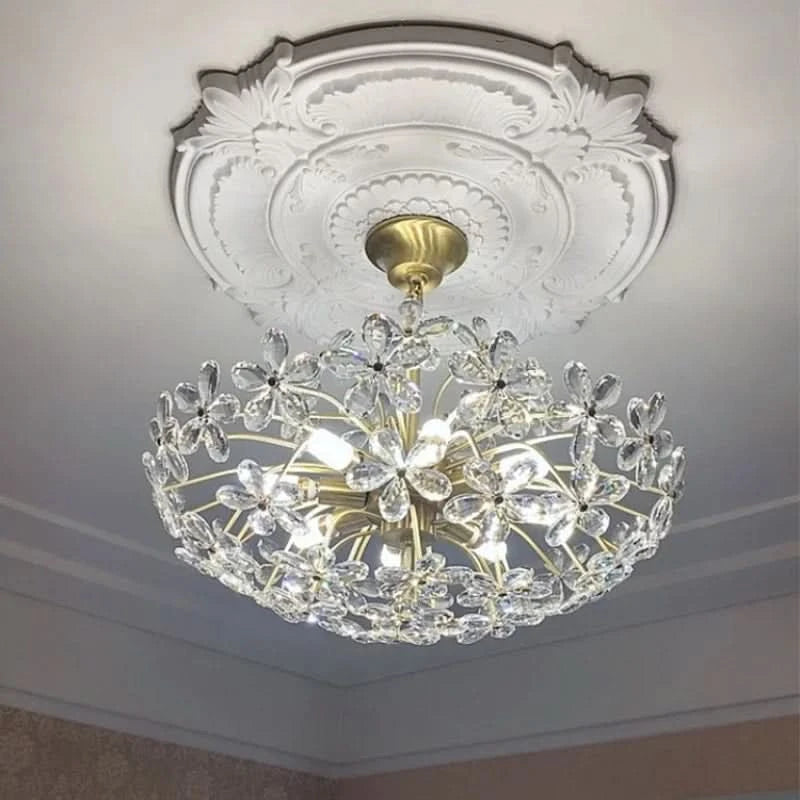 Lustre installé au plafond sur rosace ouvragée, vue en contre-plongée avec lumière allumée.