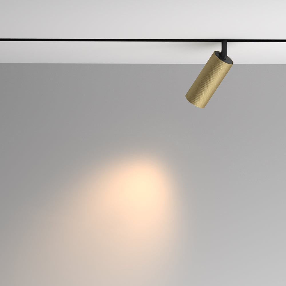 Spot doré orienté vers le mur, halo de lumière chaude projeté
