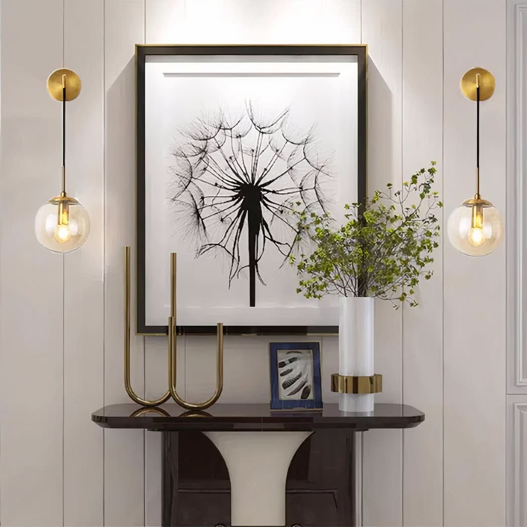 Appliques dorées encadrant une affiche de pissenlit sur un mur blanc avec console