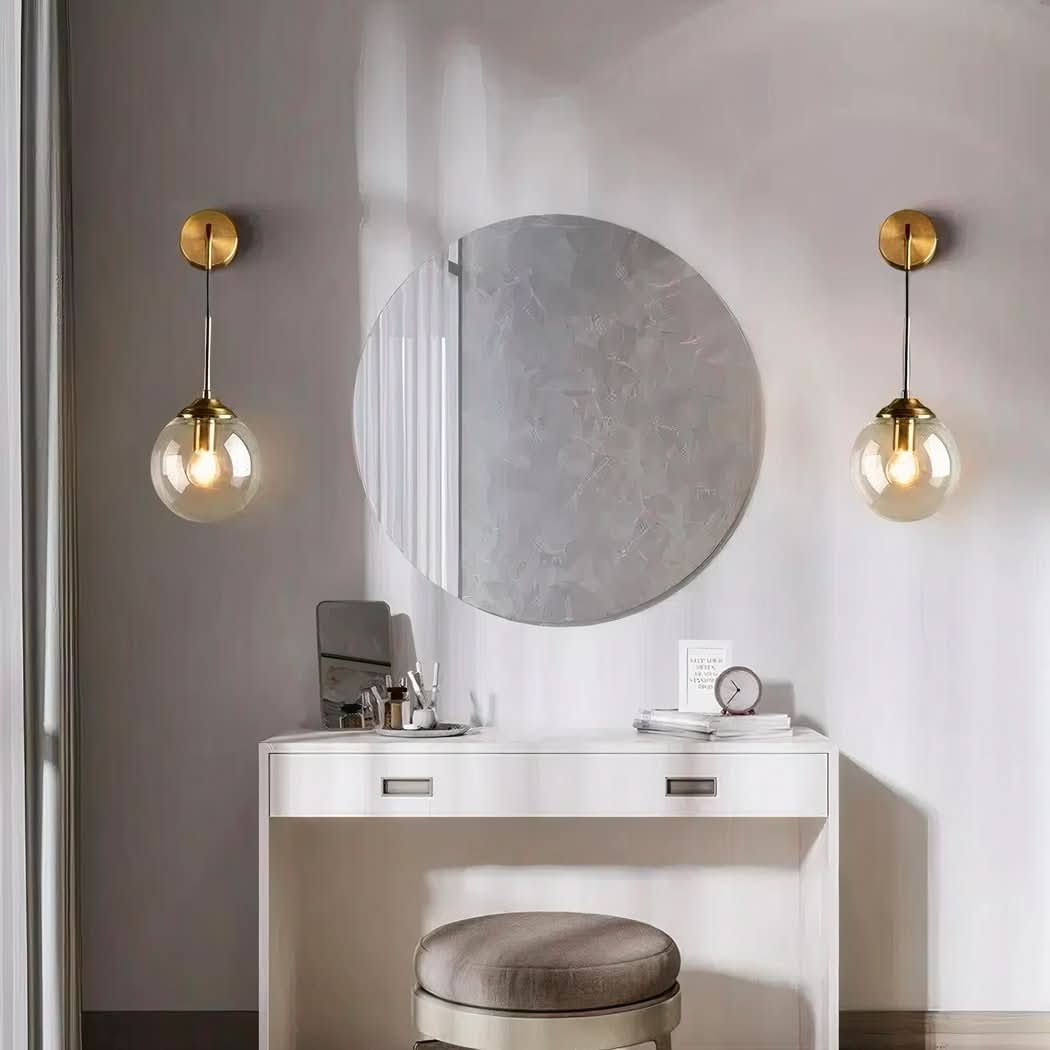 Mise en ambiance dans une salle de bain, deux appliques de part et d'autre d'un miroir rond