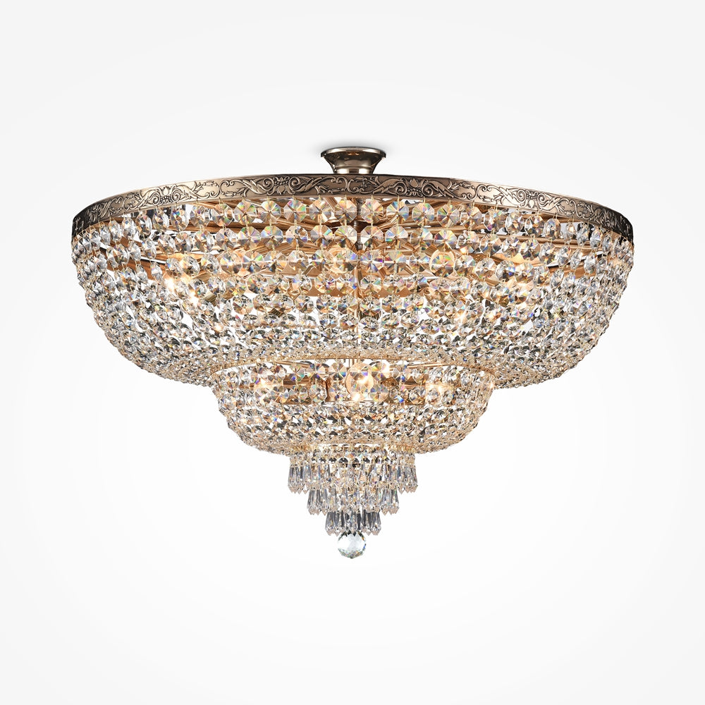 Lustre doré de plafond, immense coupe en cristal à étages, fond blanc.