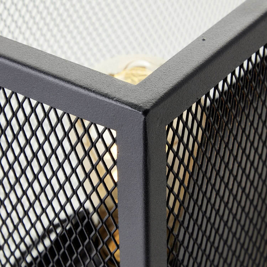Détail rapproché d'un angle en métal noir texturé et de la grille.