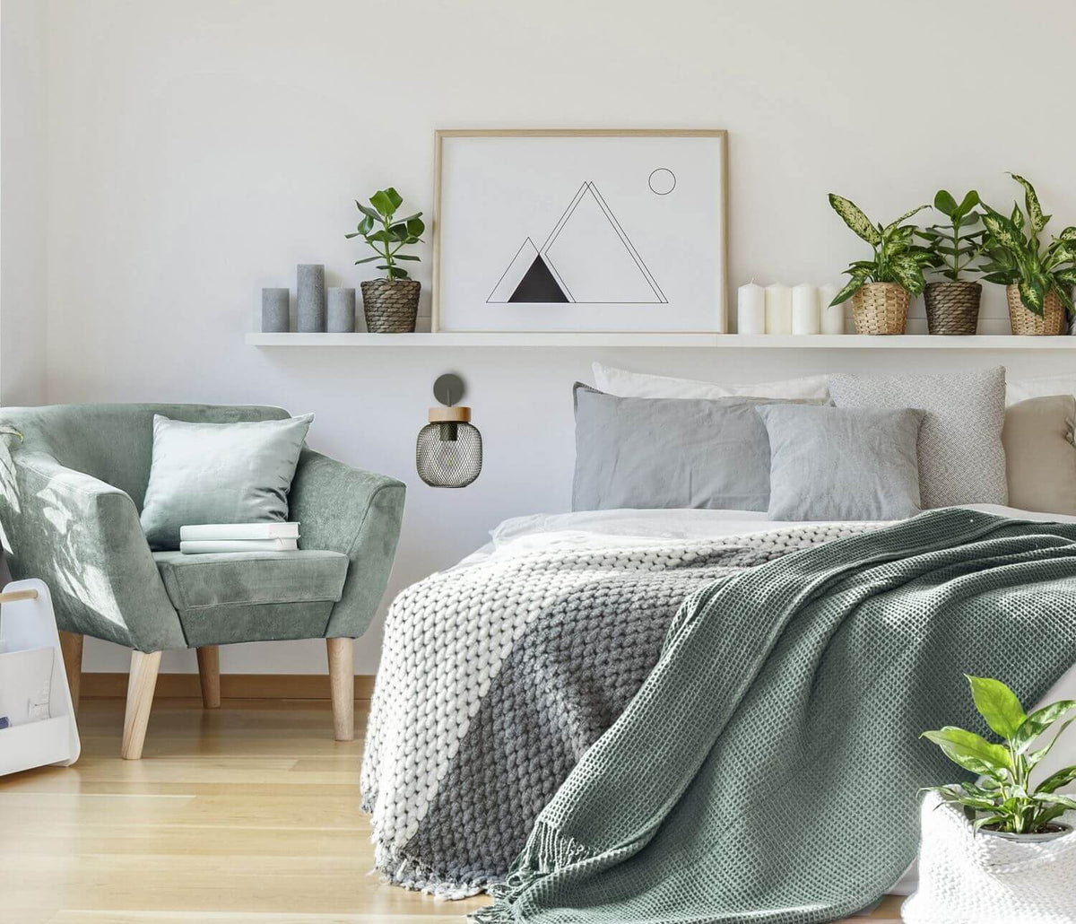 Applique murale installée dans une chambre, au-dessus d’un lit gris et vert.