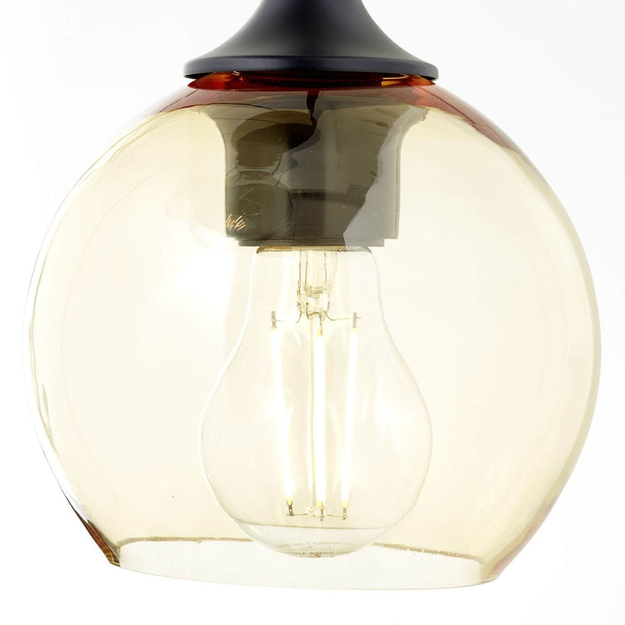 Gros plan sur un globe en verre ambré et son ampoule à filament.