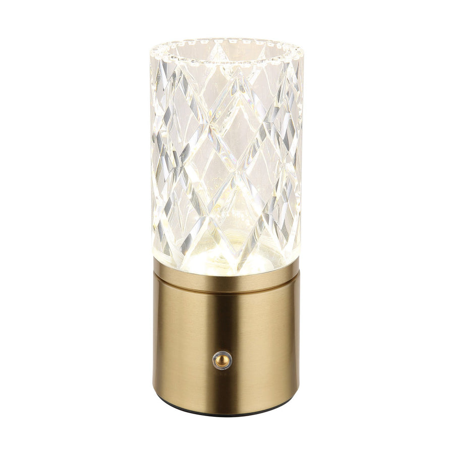 Lampe à poser de face sur fond blanc, base laiton et cylindre cristal allumé.