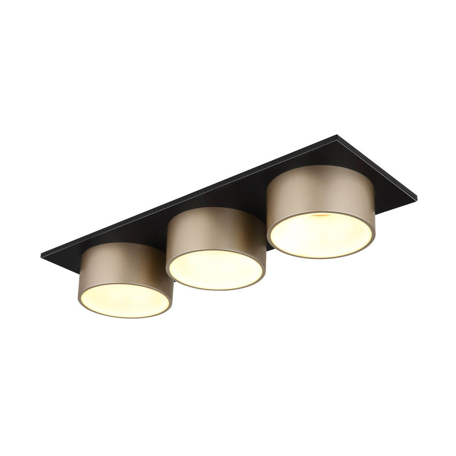 Plafonnier trois spots cylindriques dorés sur platine rectangulaire noire, vue de trois quarts