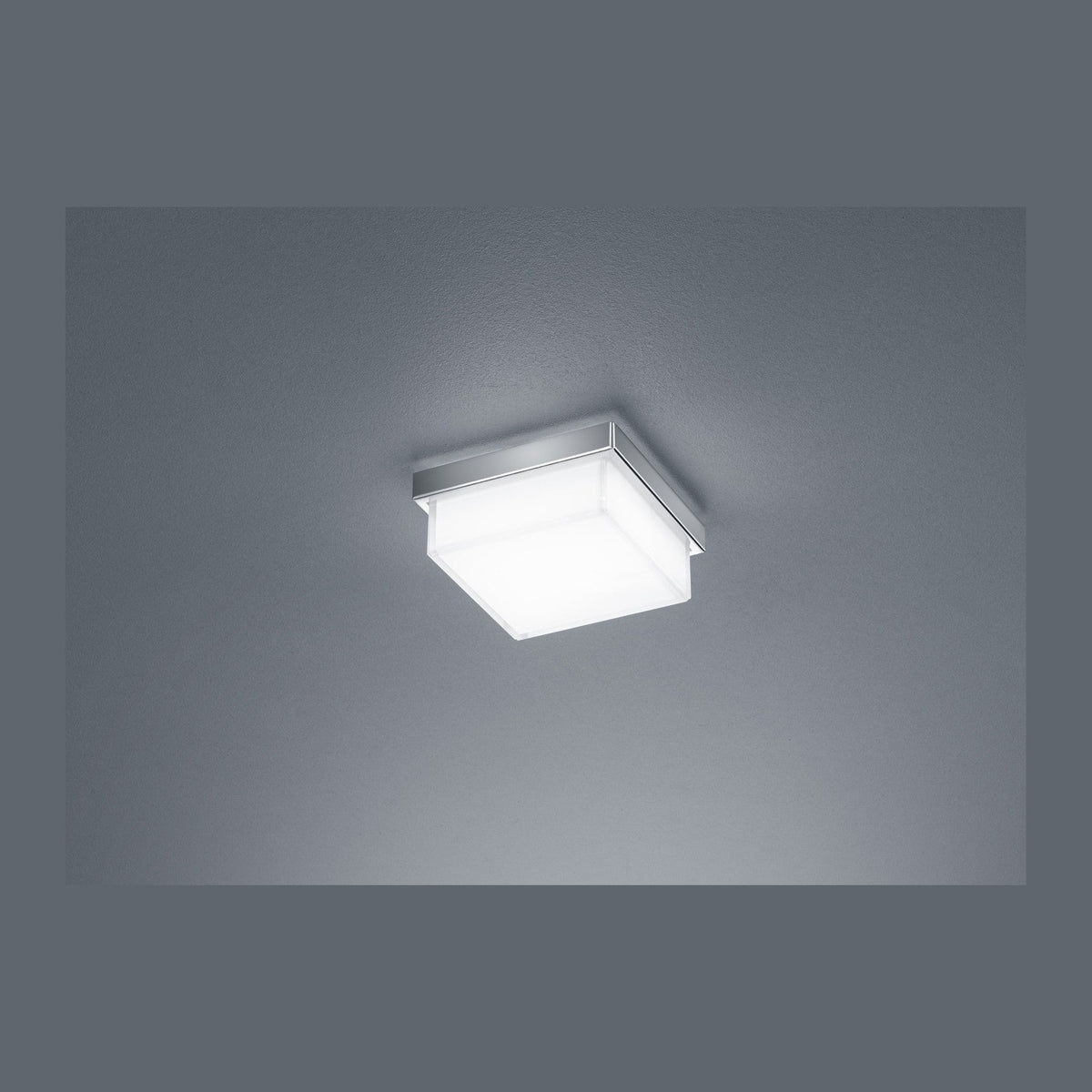 Vue de face d'un plafonnier carré blanc éclairé, cadre nickel fin.