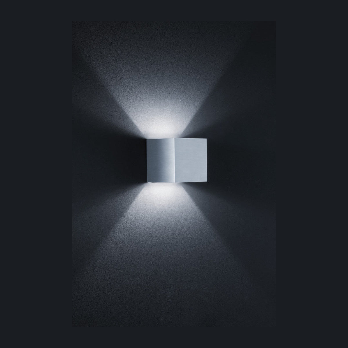 Applique carrée en aluminium gris diffusant deux faisceaux lumineux verticaux sur un mur sombre
