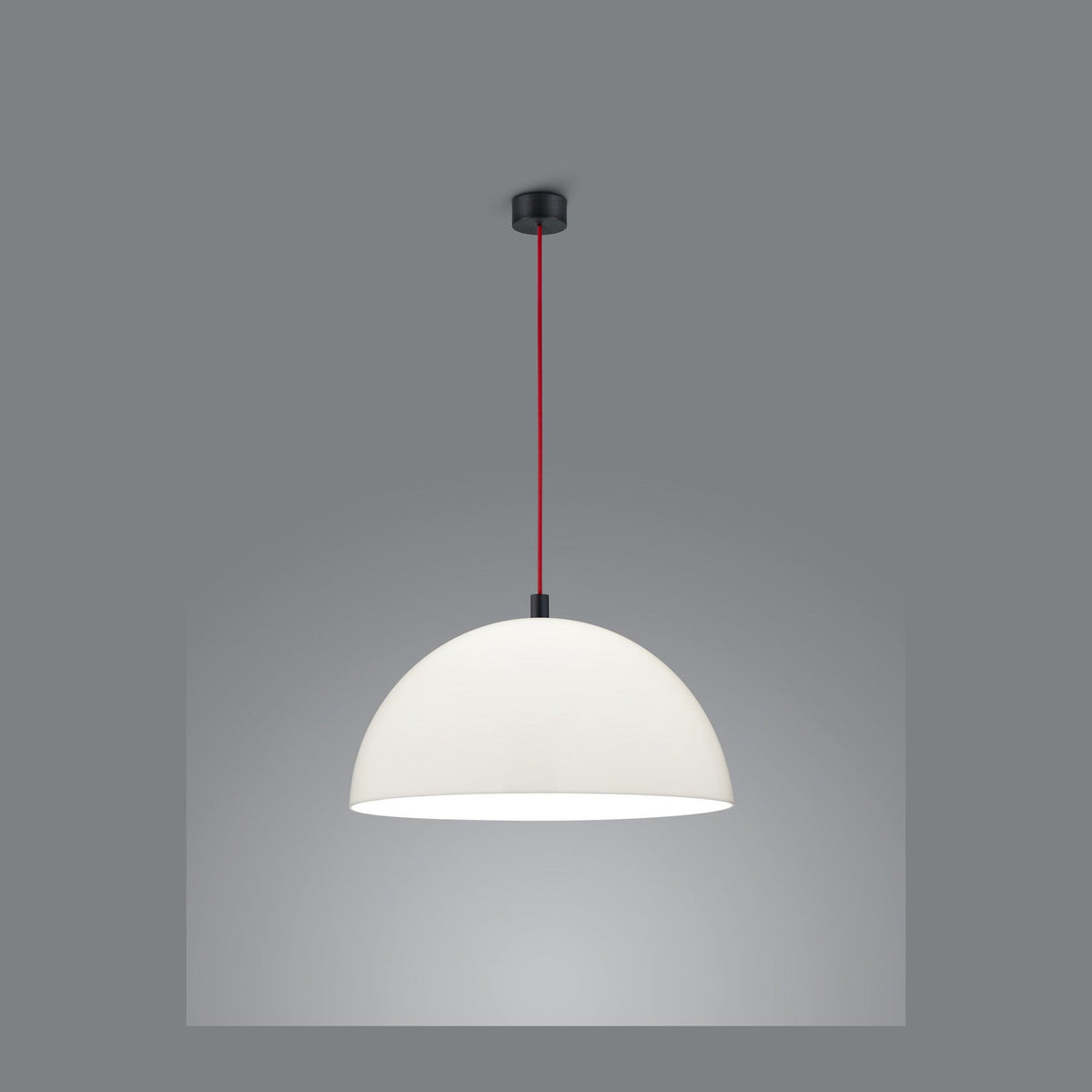 Suspension blanche en forme de dôme, câble rouge et fixation noire sur fond gris.