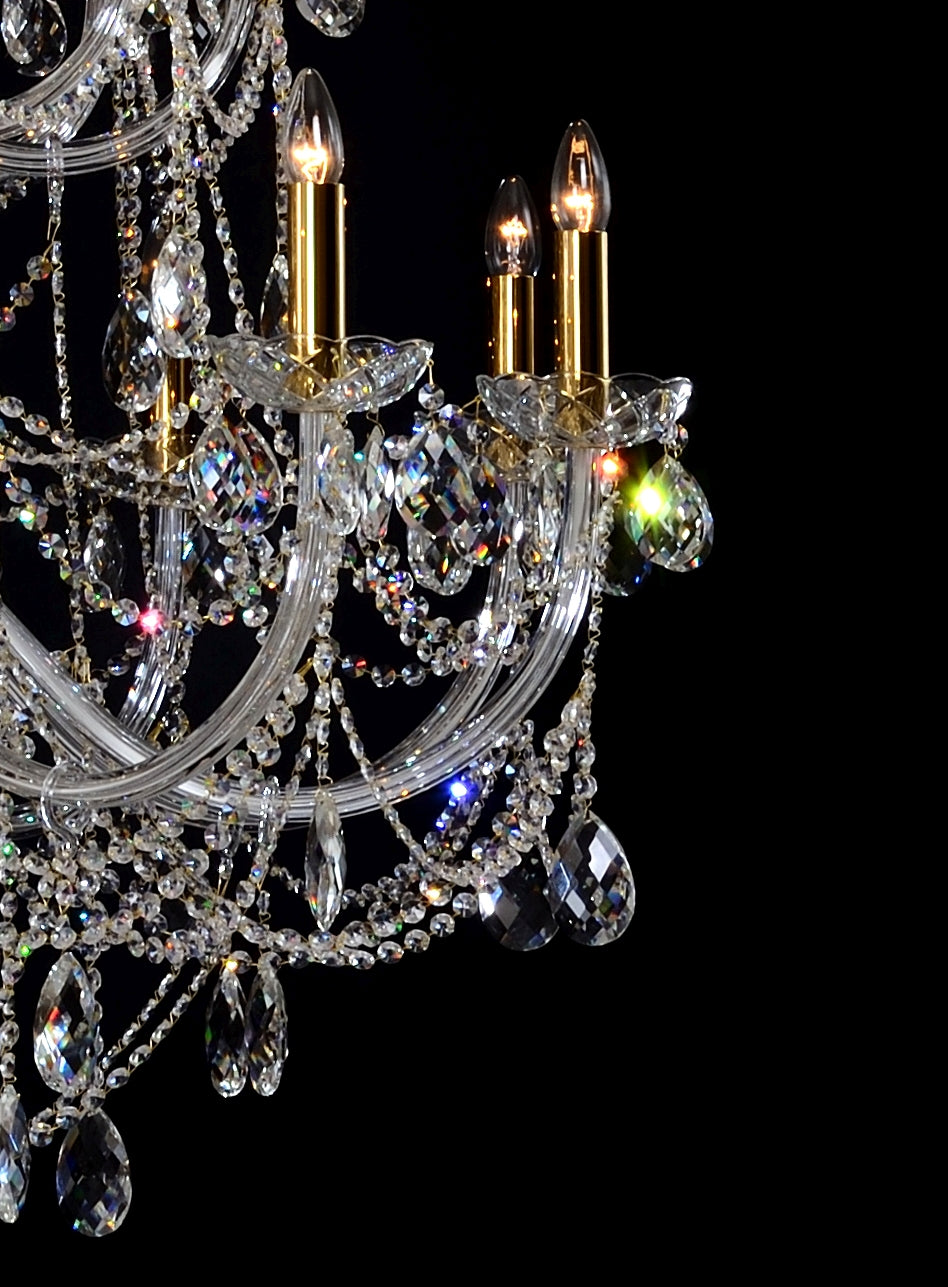 Détail des bras de lumière dorés et pendeloques en cristal taillé aux reflets irisés