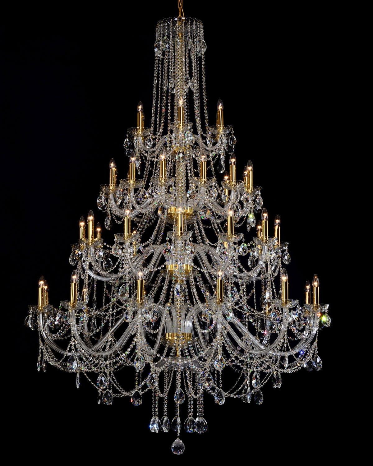 Lustre en cristal de face, nombreuses bras dorés et pampilles scintillantes sur fond noir