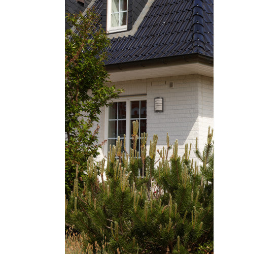 Mise en ambiance extérieure : applique anthracite fixée sur un mur près d'une fenêtre.
