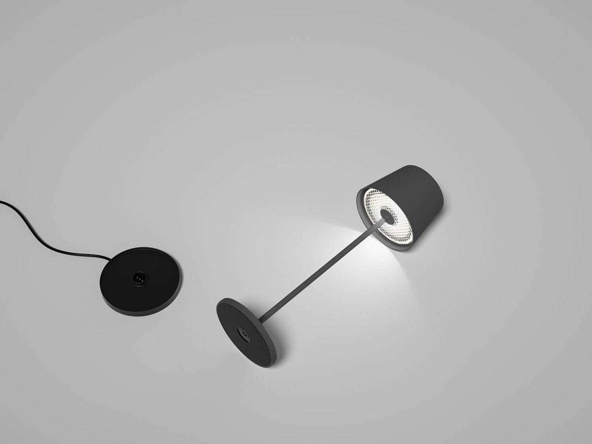 Lampe sans fil détachée de sa base, éclairée dans une ambiance sombre.