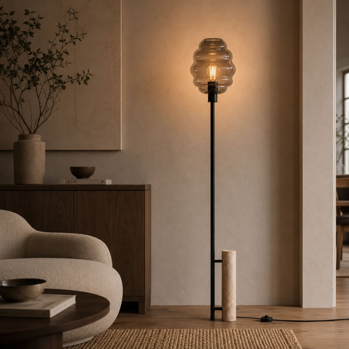 Abat-jour en verre fumé côtelé éclairé, meuble en bois et fauteuil beige