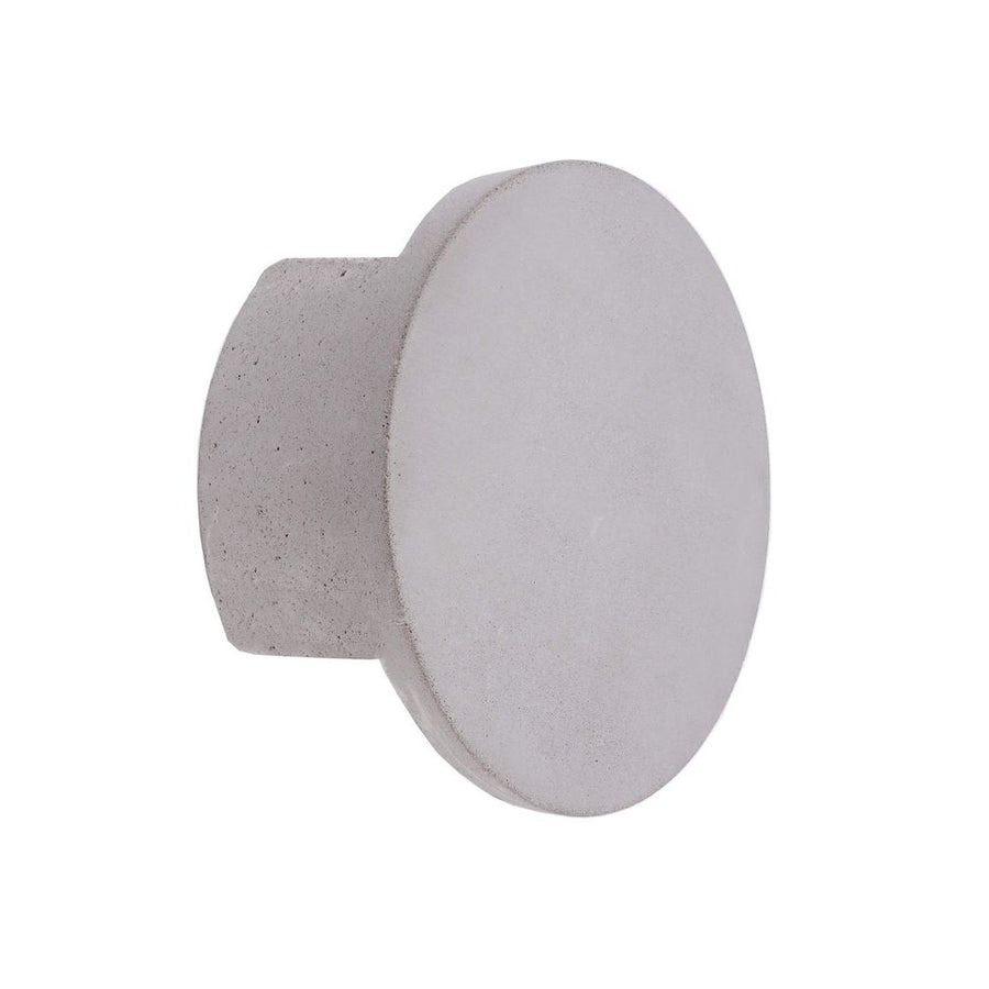 Vue de profil de l’applique ronde en béton gris, sur fond blanc.