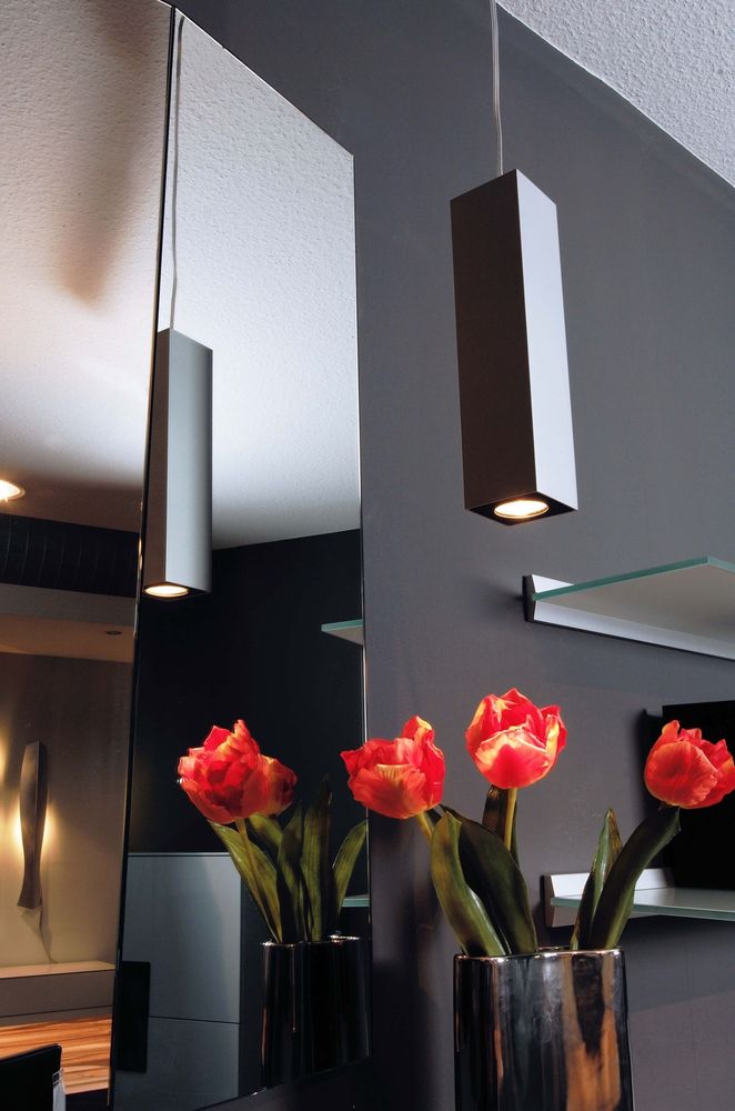 Mise en ambiance avec deux suspensions devant un miroir et des tulipes