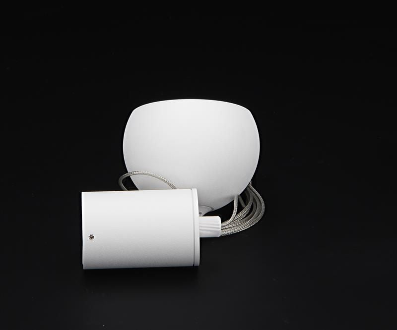 Abat-jour sphérique blanc posé près du boîtier cylindrique et de son câble gainé.