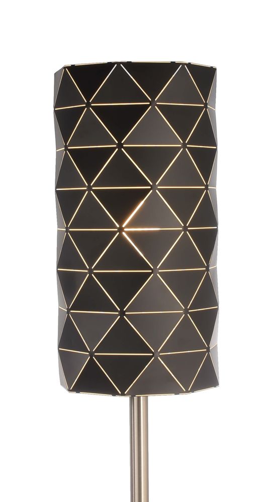 Gros plan sur l’abat-jour noir, motifs triangulaires laissant passer une lumière chaude.