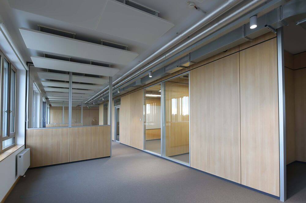 Spot blanc installé au plafond dans un couloir de bureaux moderne.