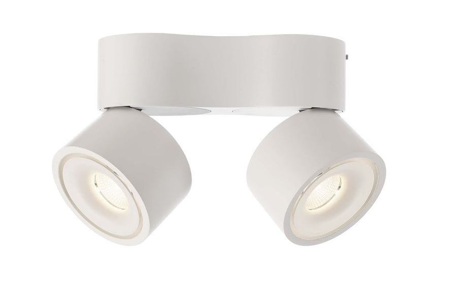 Détail de face du luminaire blanc, deux projecteurs inclinés vers le bas et allumés.