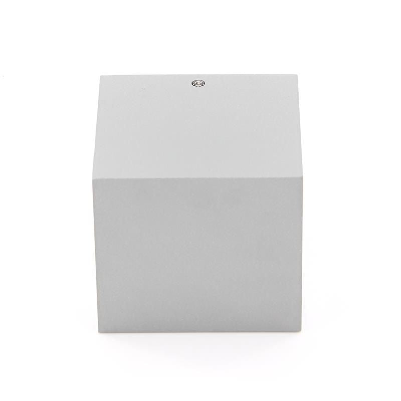 Face avant fermée du boîtier cubique gris clair, avec vis visible en haut.