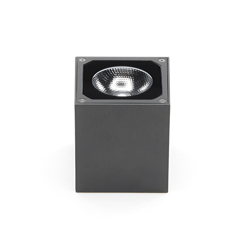 Vue de face du boîtier cubique gris avec réflecteur et lentille visibles sur le dessus.