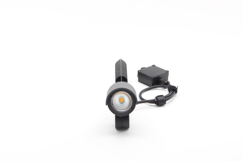 Vue de face du projecteur gris, lentille LED ronde et câble avec boîtier étanche.