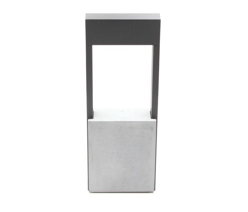 Vue de face du lampadaire, cadre rectangulaire sombre sur socle en béton clair.