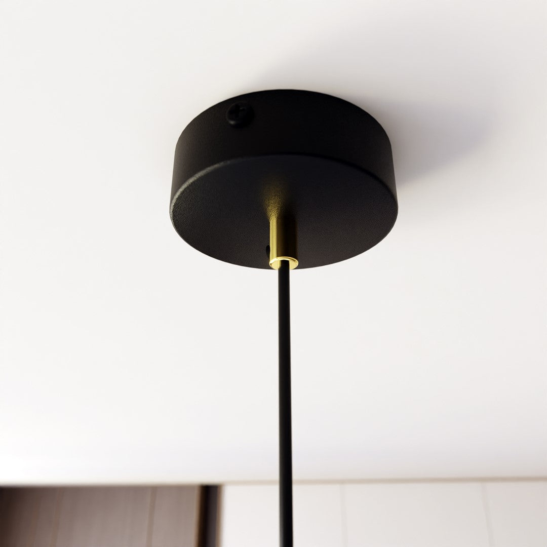 Détail de la rosace noire au plafond et du câble noir avec raccord doré.