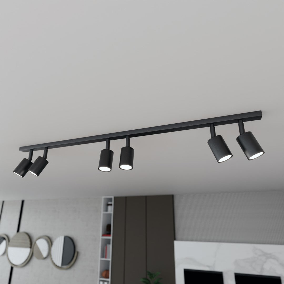 Vue en plongée du luminaire noir au plafond, au-dessus du salon et de la cuisine ouverte.