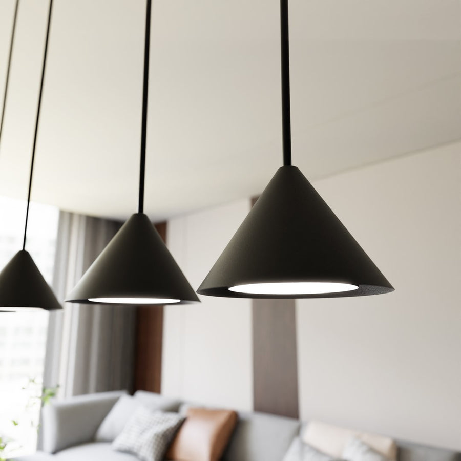 Gros plan sur les abat-jours coniques noirs et leur lumière blanche au plafond.