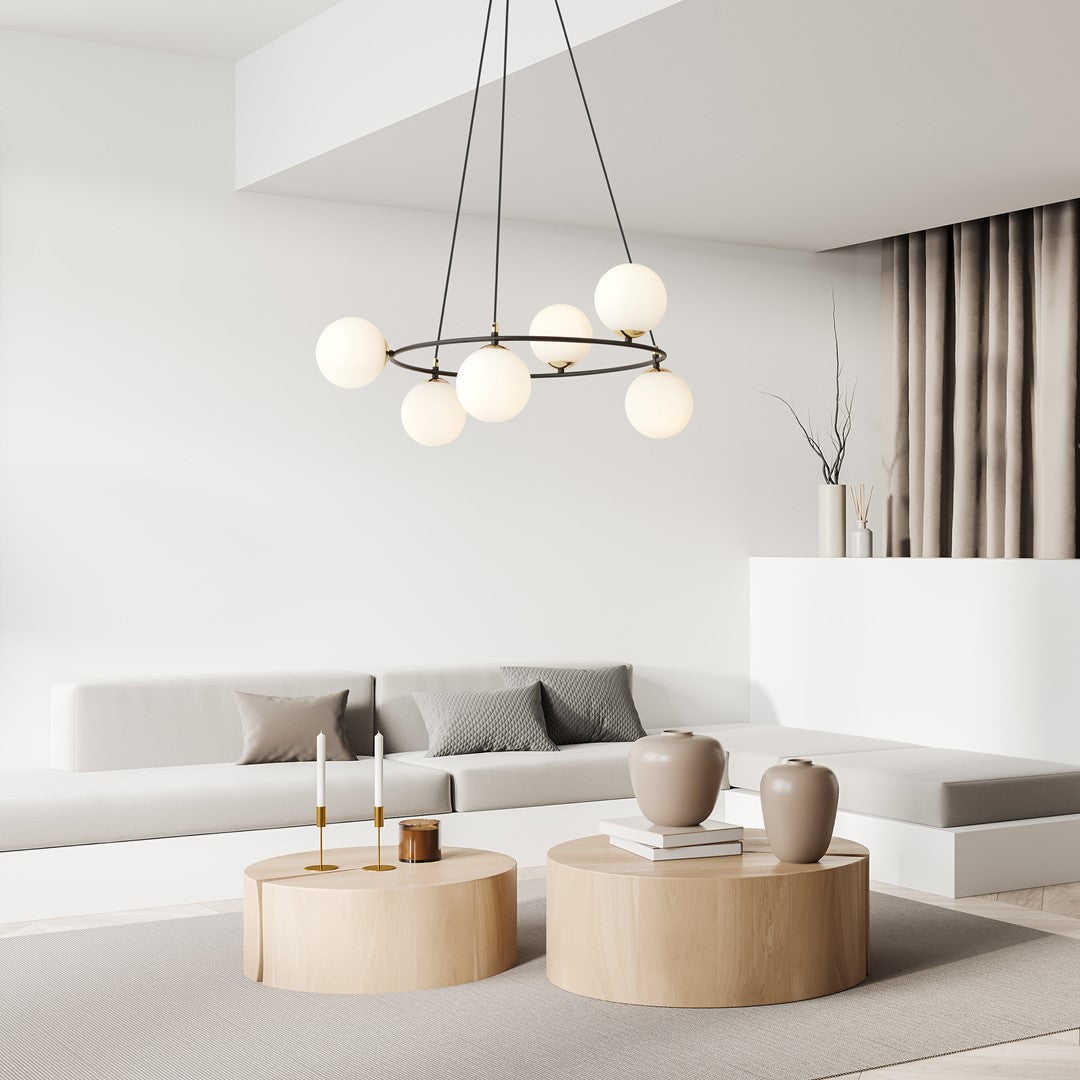 Suspension installée au-dessus d'un salon minimaliste avec canapé clair et tables bois