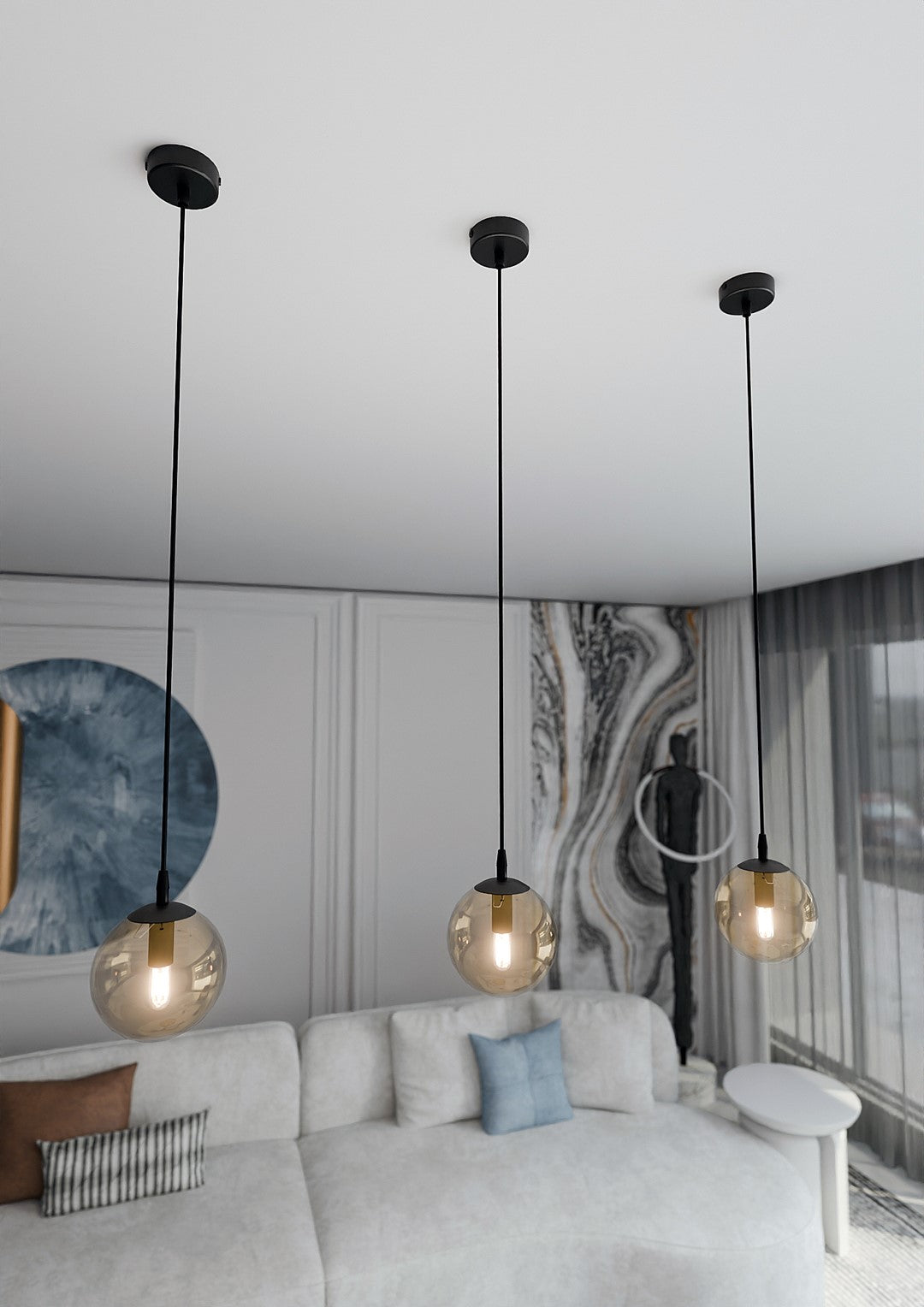 Trois globes ambrés suspendus devant un mur décoratif, vue en contre-plongée.