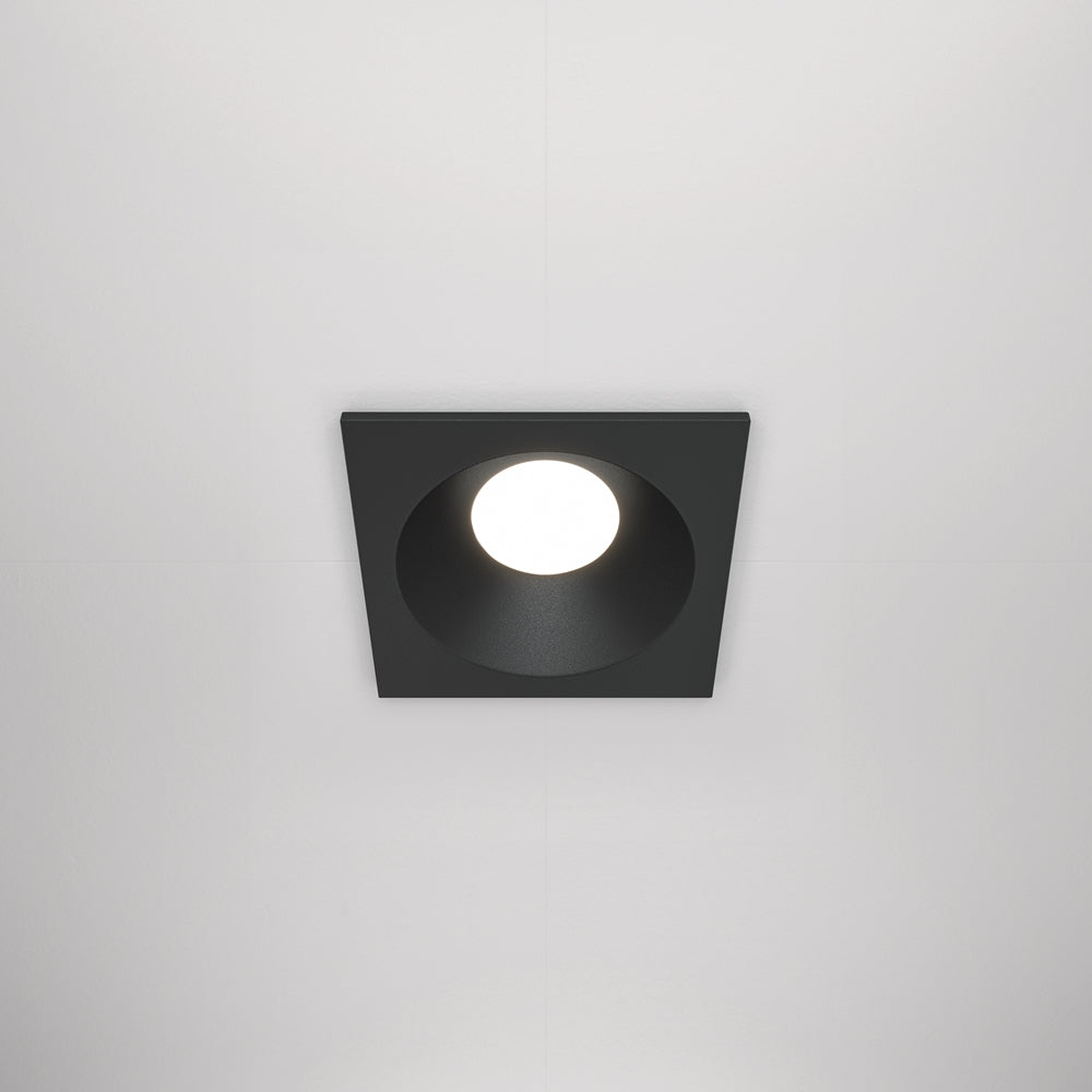 Spot encastré carré noir vu de face sur un plafond blanc uni