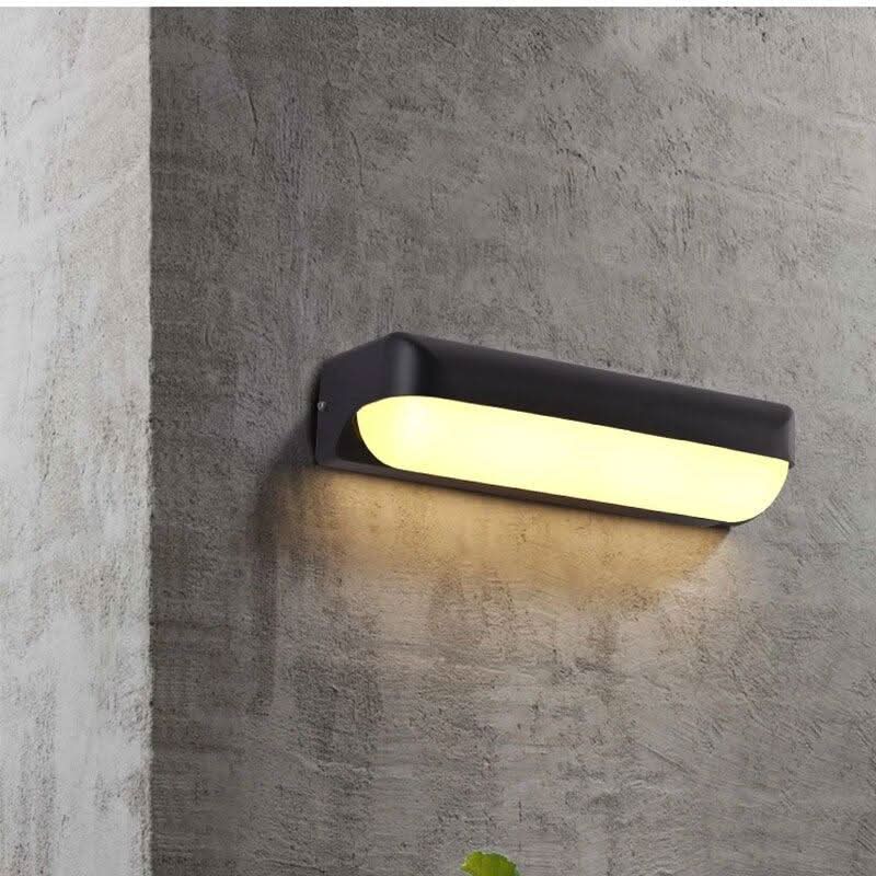 Vue de face du luminaire fixé sur un mur béton gris, diffuseur blanc lumineux