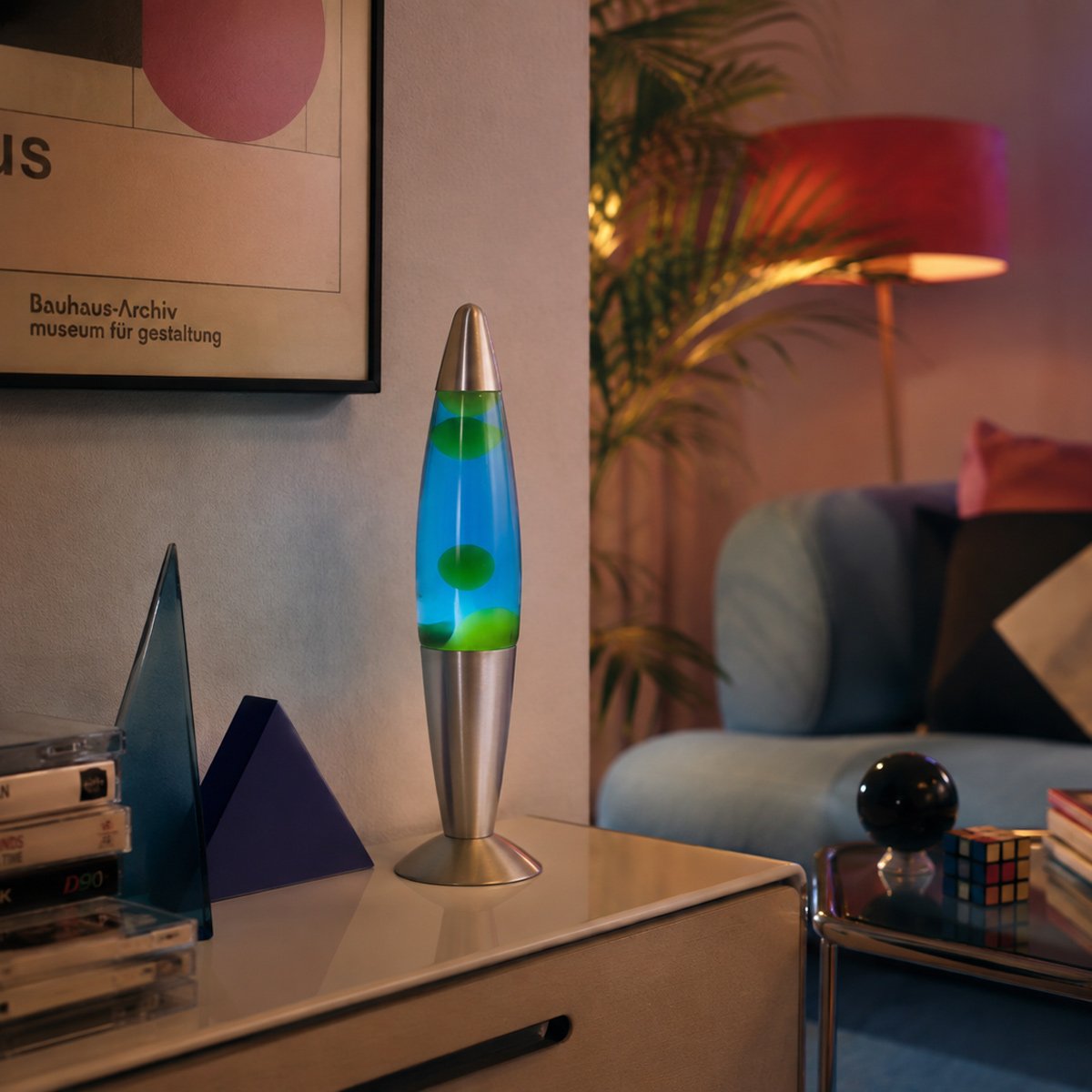 Mise en ambiance dans un salon, lampe posée sur un meuble, décor rétro et végétal.