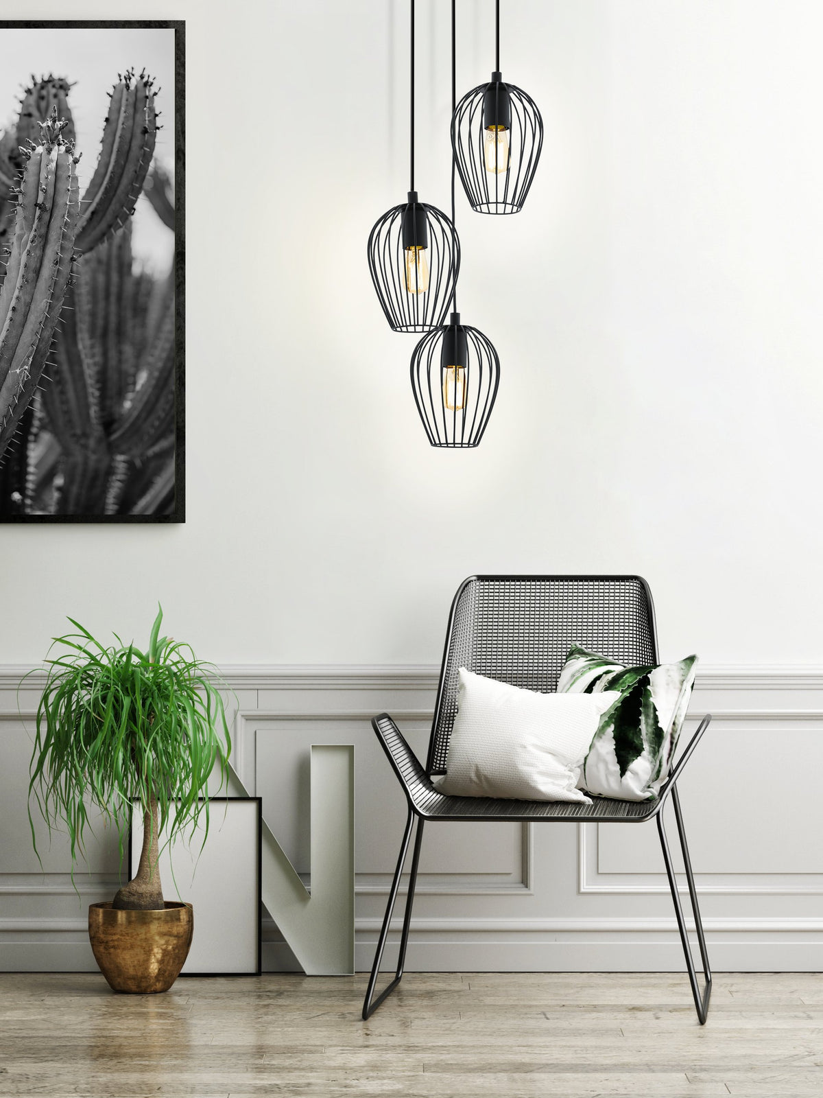 Mise en ambiance dans un salon clair avec fauteuil et tableau de cactus