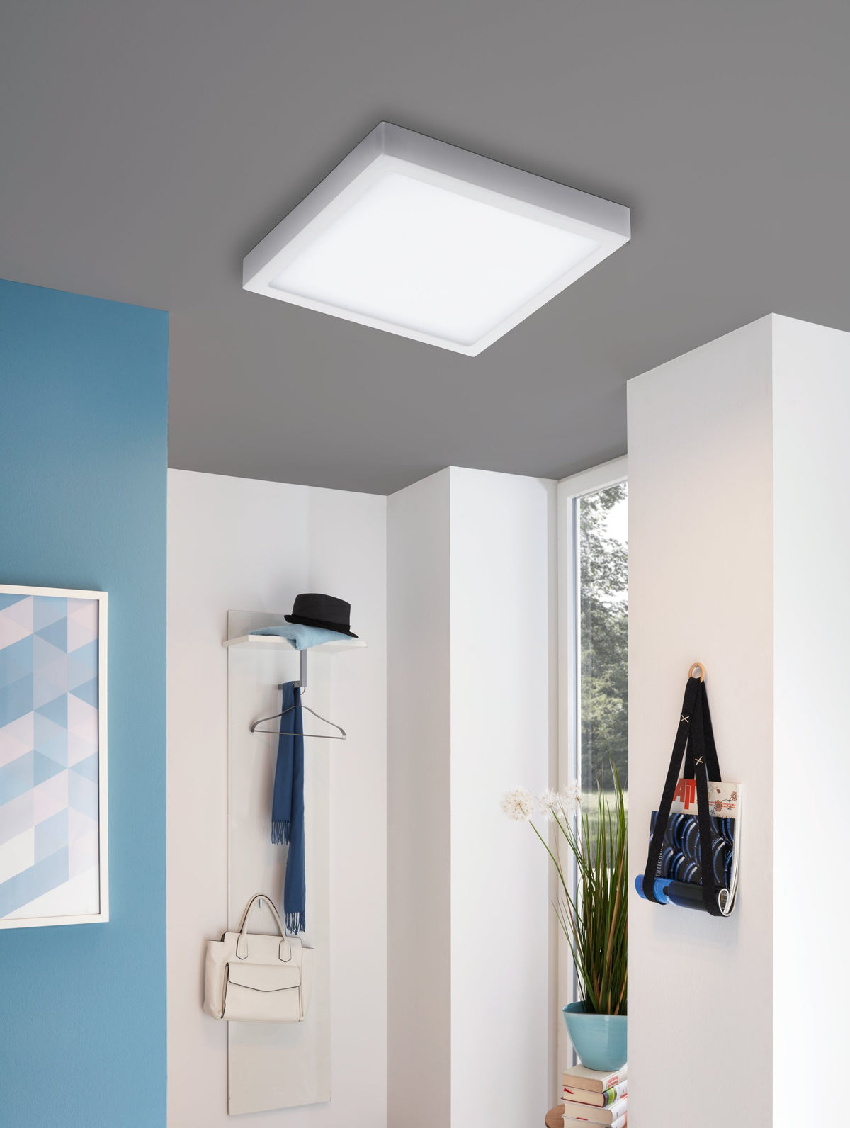 Plafonnier blanc carré installé au plafond dans une entrée moderne.