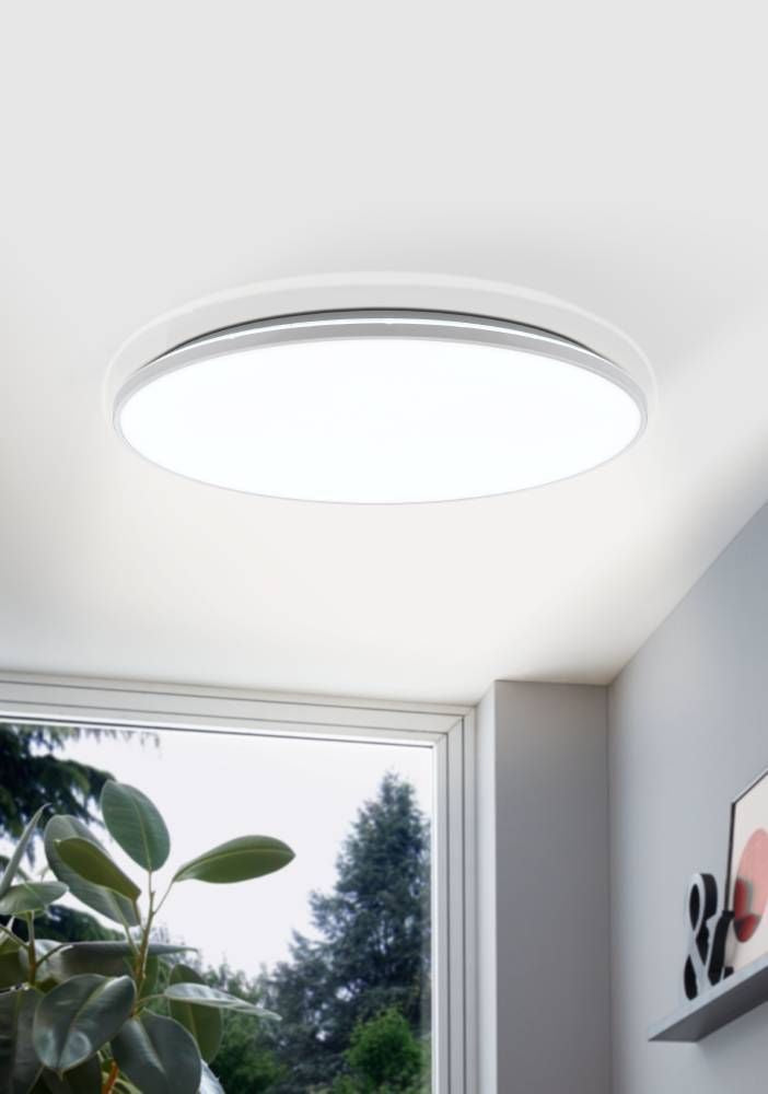 Mise en ambiance du plafonnier blanc fixé au plafond près d'une fenêtre et de plantes
