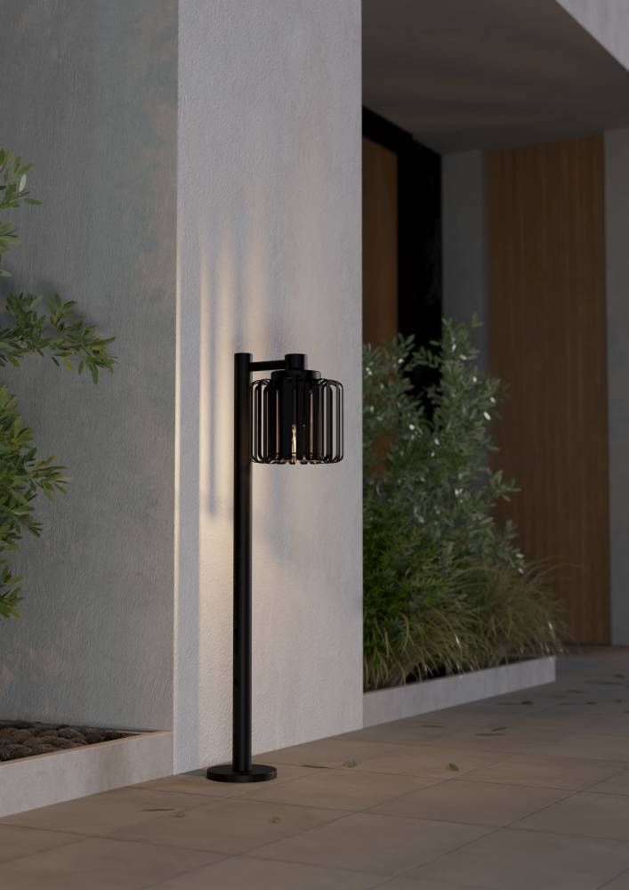 Mise en ambiance nocturne du lampadaire allumé le long d'un mur devant des plantes