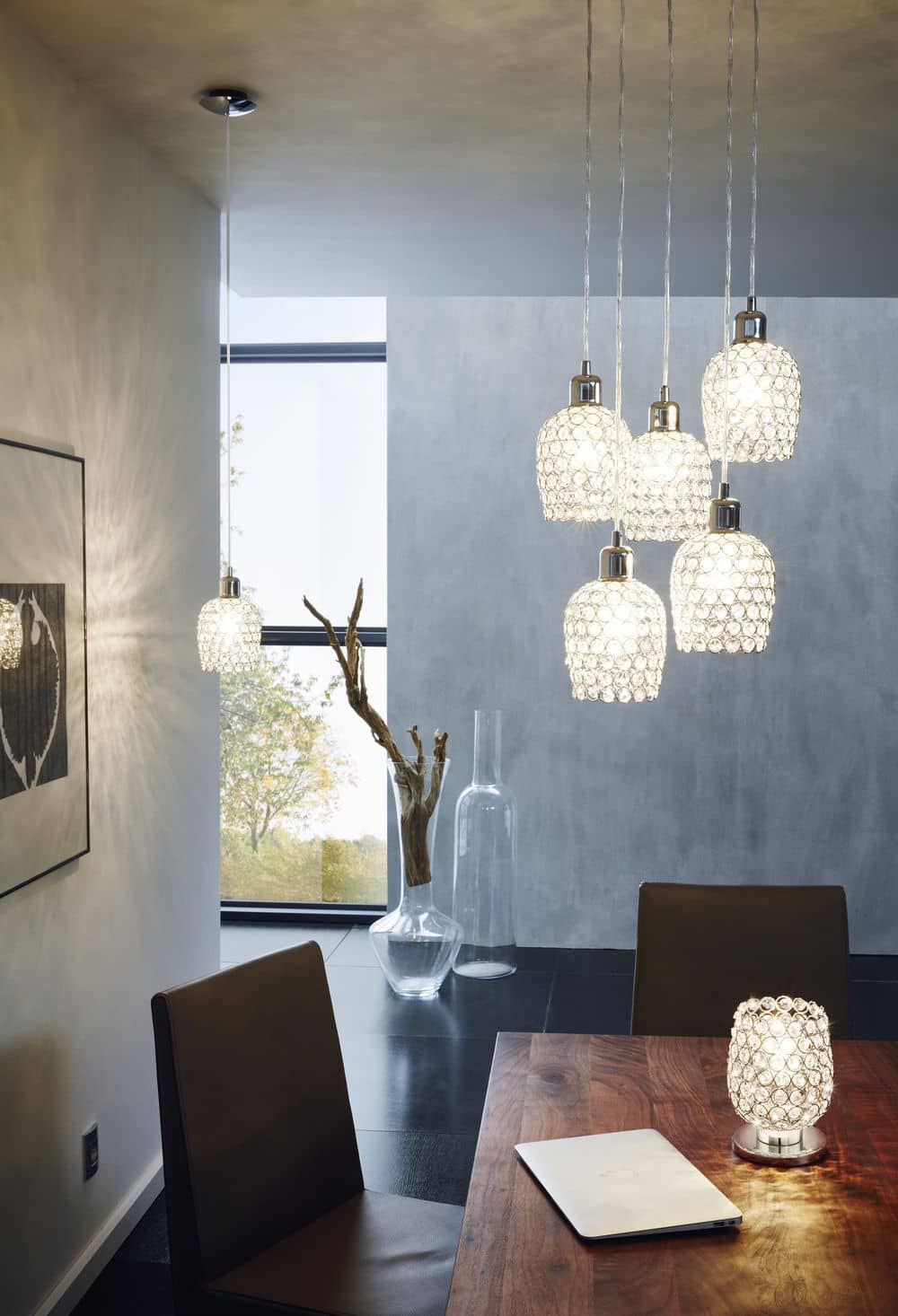 Mise en ambiance de plusieurs suspensions cristal au-dessus d'une table de salle à manger