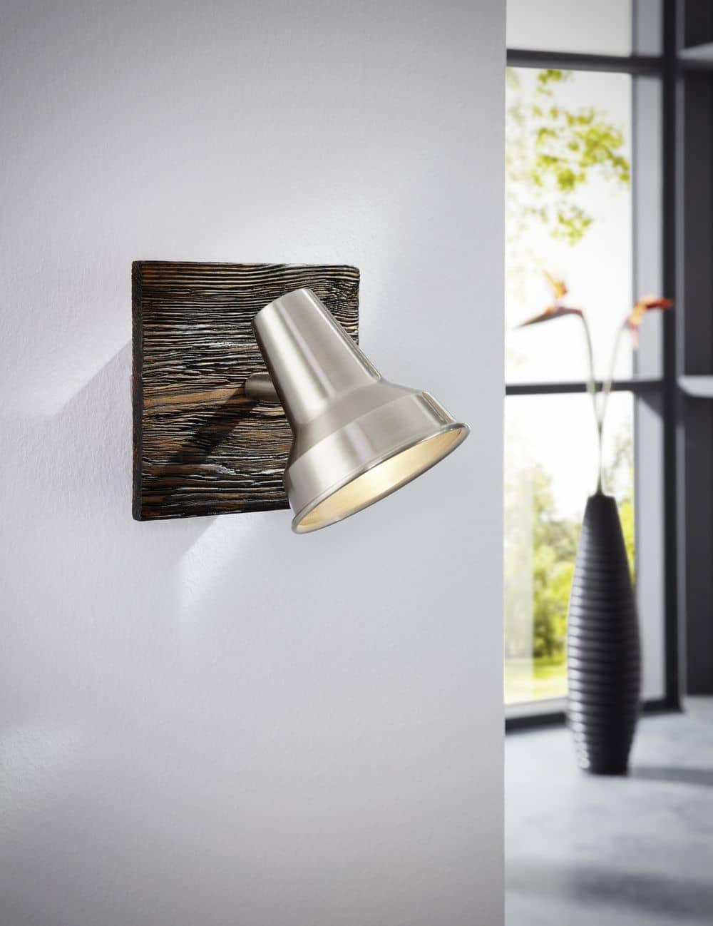 Applique fixée au mur dans un salon clair, près d'une fenêtre et d'un vase noir